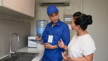 Plumber speaking with client.